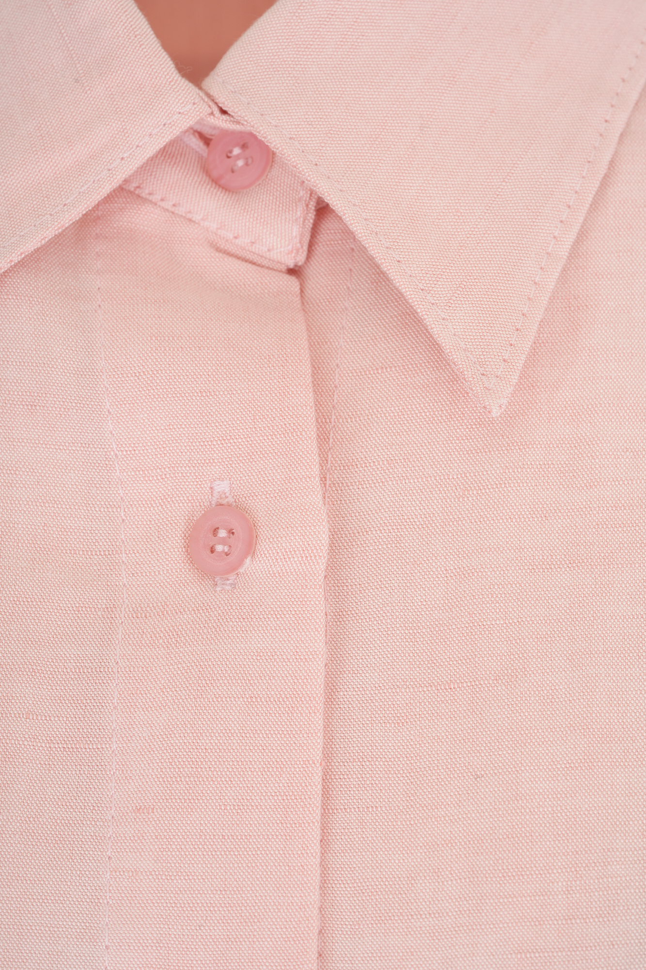 Close-up image of a light pink buttoned shirt collar showcasing detailed stitching and texture perfect for office or casual wear offering style and comfort.