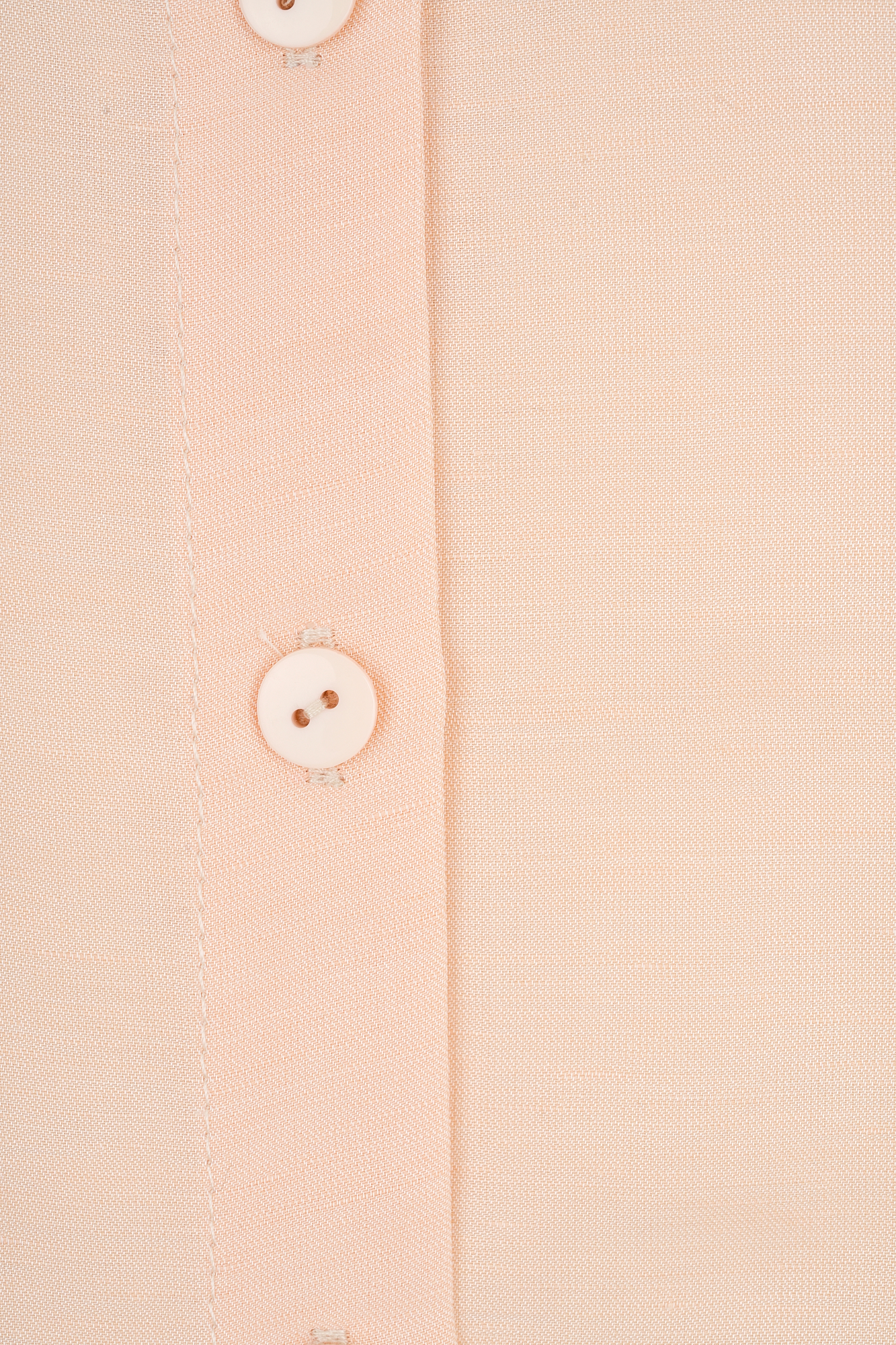 Close-up of a light beige dress shirt showcasing the fabric texture and button details. Ideal for highlighting clothing quality and design in fashion photography and retail.