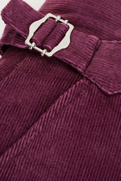 High-waisted tailored trousers in deep purple Italian corduroy fabric, featuring adjustable side buckles and a sleek tapered design.