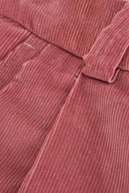 A pair of stylish pink corduroy trousers with a high-waisted design. The trousers feature wide-leg cuts and belt loops for added versatility, perfect for a chic and modern outfit.