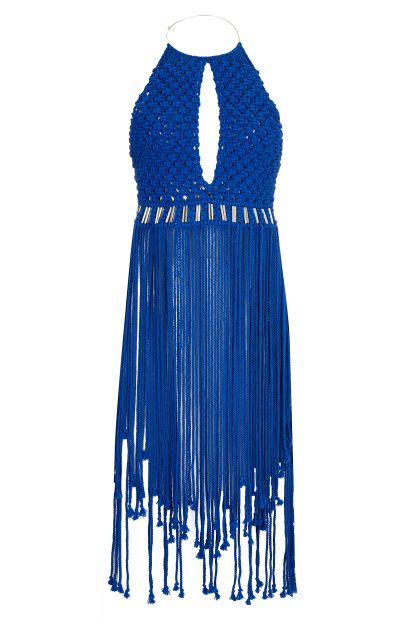 A striking blue macramé dress featuring a halter neckline with a teardrop cut-out at the chest. The dress is intricately woven with metallic accents at the waist and has long fringed strands that flow from the hips, adding a dynamic and elegant touch.